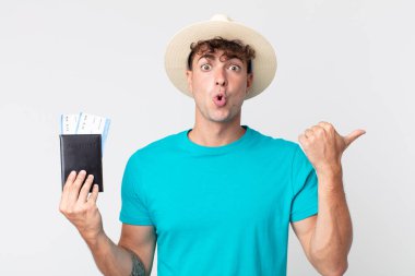 İnanamadığı için şaşırmış genç ve yakışıklı bir adam. Elinde pasaportu olan bir yolcu.