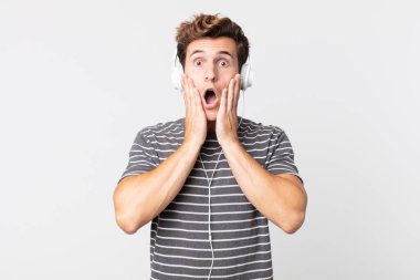 Genç ve yakışıklı bir adam şok olmuş ve korkmuş hissediyor. müzik konseptini dinlemek