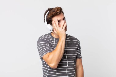 Genç yakışıklı bir adam bıkkın, hayal kırıklığına uğramış ve yorucu bir geceden sonra uykulu hissediyor. müzik konseptini dinlemek