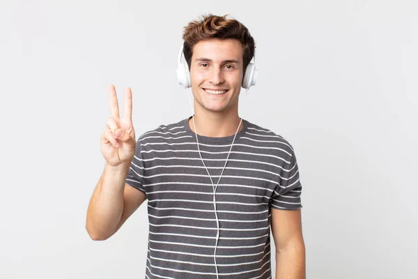 Jonge Knappe Man Glimlachend Vriendelijk Toont Nummer Twee Luisteren Muziek — Stockfoto