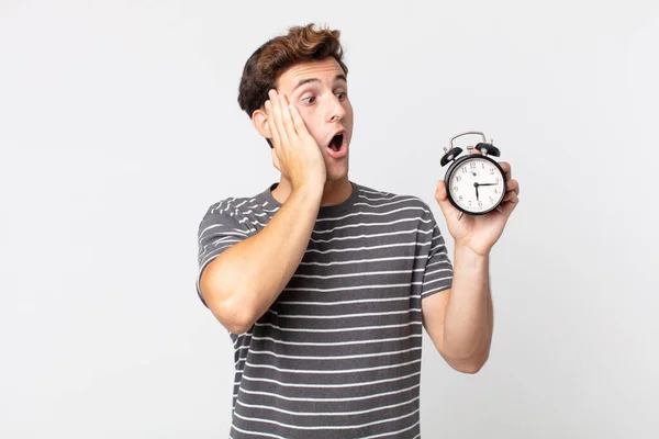 Jovem Bonito Homem Sentindo Feliz Animado Surpreso Segurando Despertador — Fotografia de Stock