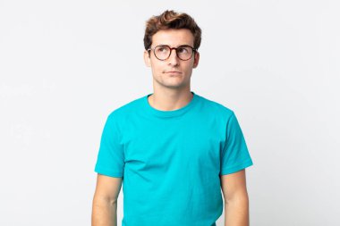 Genç ve yakışıklı adam kafası karışmış görünüyor, merak ediyor ya da bir sorunu çözmeye çalışıyor ya da düşünüyor.