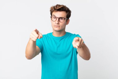 Genç ve yakışıklı bir adam kameraya hem parmaklarını hem de kızgın yüzünü göstererek sana görevini yapmanı söylüyor.