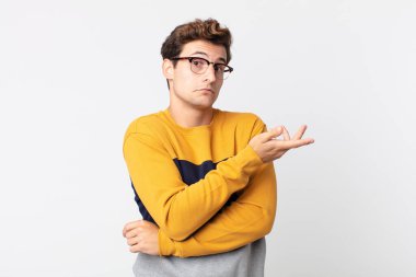 Genç yakışıklı bir adam kafası karışık ve bilgisiz, şüpheli bir açıklama ya da düşünceyi merak ediyor.