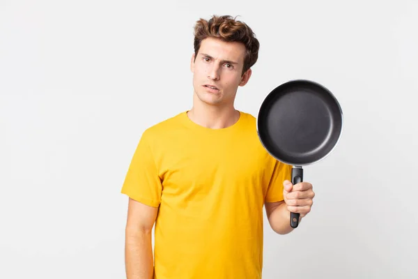 Joven Guapo Hombre Sintiéndose Perplejo Confundido Sosteniendo Una Sartén Cocinero — Foto de Stock