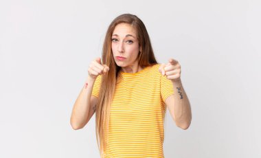 Oldukça zayıf bir kadın kameraya doğru işaret ediyor. Hem parmakları hem de kızgın bir ifadeyle. Sana görevini yapmanı söylüyor.