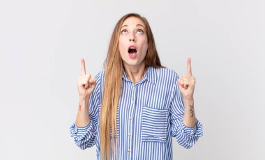 Oldukça zayıf bir kadın korkuyla ve ağzı açık bir şekilde şaşkın ve şaşkın bir bakışla yukarıya bakıyor.