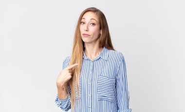 Oldukça zayıf bir kadın gururlu, kendinden emin ve mutlu görünüyor, gülümsüyor ve kendini işaret ediyor ya da bir numara işareti yapıyor.