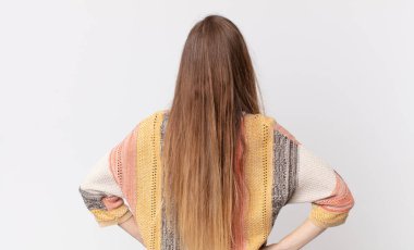 Oldukça ince bir kadın kafası karışık ya da dolgun ya da şüphe ve soru dolu, merak ediyor, elleri kalçasında, dikiz aynasından.