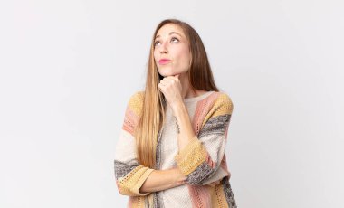 Oldukça ince bir kadın düşünceli, meraklı ya da hayal kuruyor, hayal kuruyor ve uzayı kopyalamak için yukarı bakıyor.