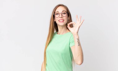 Oldukça zayıf bir kadın kendini mutlu, rahat ve tatmin olmuş hissediyor, iyi bir jestle onaylıyor, gülümsüyor