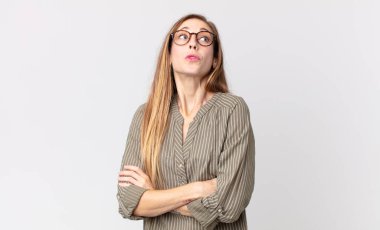 Oldukça zayıf bir kadın omuz silkiyor, kafası karışık ve kararsız, kolları bağlı ve şaşkın görünüyor.