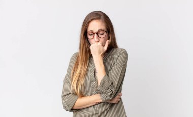 Oldukça zayıf bir kadın. Ciddi, düşünceli ve endişeli. Eli çenesine değmiş şekilde yan yan bakıyor.