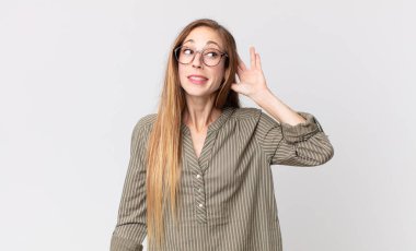 Oldukça zayıf bir kadın gülümsüyor, tuhaf bir şekilde yan tarafa bakıyor, dedikoduları dinlemeye ya da bir sırrı duymaya çalışıyor.