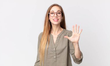 Oldukça zayıf bir kadın gülümsüyor ve arkadaş canlısı görünüyor, 5 ya da 5 numarayı gösteriyor, elleri önde, geri sayıyor.