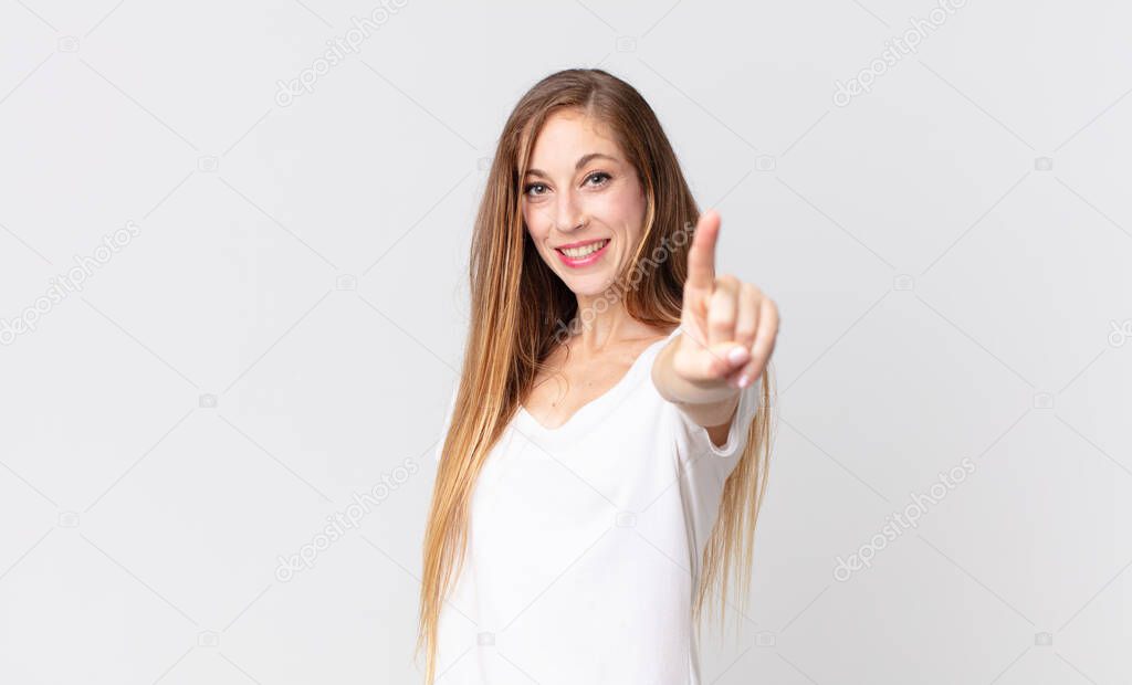 pretty thin woman smiling proudly and confidently making number one pose triumphantly, feeling like a leader