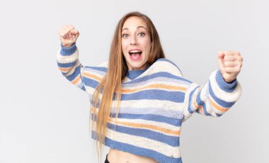 Oldukça zayıf bir kadın zaferle bağırıyor. Heyecanlı, mutlu ve şaşırmış görünüyor. Kutlama yapıyor.