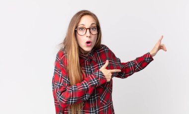 Oldukça zayıf bir kadın şaşkın ve şaşırmış hissediyor. Yan taraftaki fotokopi alanını işaret ediyor. Şaşırmış ve ağzı açık bakıyor.