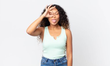 Güzel İspanyol kadın mutlu bir şekilde gülümsüyor, şaka yapıyor, gözetleme deliğinden bakıyor, sırları gözetliyor.