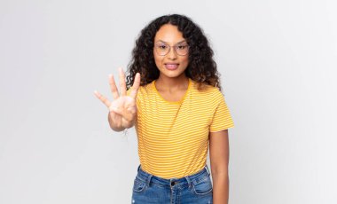 Güzel İspanyol kadın gülümsüyor ve arkadaş canlısı görünüyor. Elleri önde, geriye doğru sayıyor.