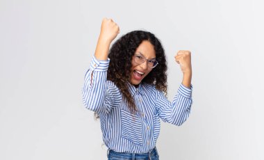 Güzel İspanyol kadın muzaffer bir şekilde bağırıyor, heyecanlı, mutlu ve şaşırmış görünüyor, kutlama yapıyor.