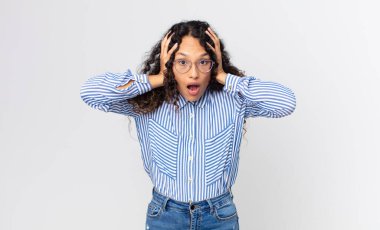 Hoş İspanyol kadın hoş olmayan bir şekilde şok olmuş, korkmuş ya da endişeli görünüyor ağzı sonuna kadar açık ve iki kulağını da elleriyle kapatıyor.