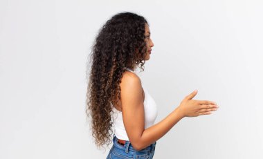 Güzel İspanyol kadın gülümsüyor, seni selamlıyor ve başarılı bir anlaşma için el sıkışmayı teklif ediyor.