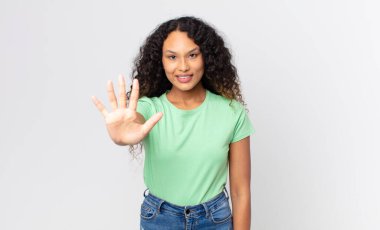 Güzel İspanyol bir kadın gülümsüyor ve arkadaş canlısı görünüyor, 5 ya da 5 numarayı gösteriyor, elleri önde, geriye doğru sayıyor.