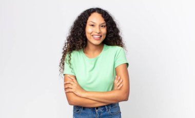 Güzel İspanyol bir kadın mutlu, gururlu ve tatmin olmuş görünüyor. Kollarını kavuşturup gülümsüyor.