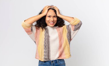 Güzel İspanyol bir kadın stresli ve endişeli, depresif ve hayal kırıklığına uğramış hissediyor, iki elini de başa kaldırıyor.