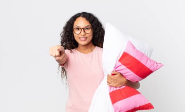 İspanyol asıllı güzel bir kadın kamerayı işaret ederek pijama giyip yastık tutarak seni seçiyor.