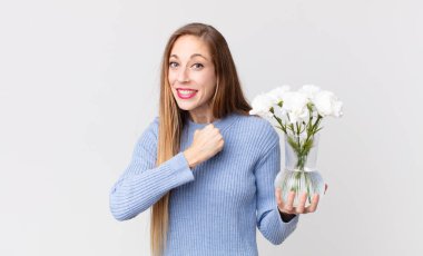 Zayıf, güzel bir kadın kendini mutlu hisseder ve meydan okumayla yüzleşir ya da Çiçeklerle bir vazo tutup onu kutlar.