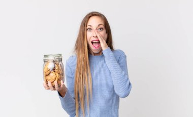 Zayıf, güzel bir kadın mutlu hissediyordu. Elleri ağızda ve elinde kurabiyelerle bağırıyordu.