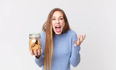 Zayıf, güzel bir kadın umutsuz görünüyor, sinirli ve stresli ve elinde kurabiye tutuyor.