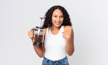 İspanyol asıllı güzel bir kadın kendini mutlu hissediyor ve manuel kahve makinesiyle heyecanlanıp kendini işaret ediyor.