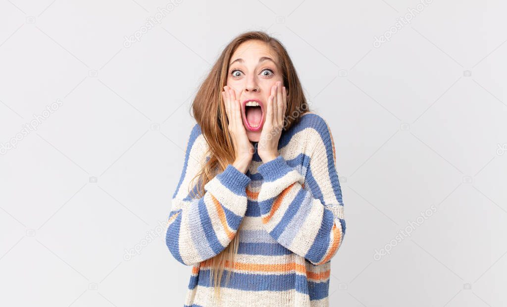 pretty thin woman feeling shocked and scared, looking terrified with open mouth and hands on cheeks