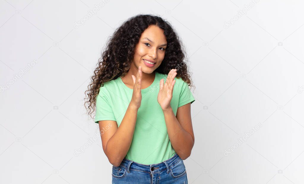 pretty hispanic woman feeling happy and successful, smiling and clapping hands, saying congratulations with an applause