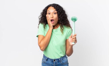 İspanyol güzel kadın şok olmuş, korkmuş ve elinde fırça tutuyormuş.