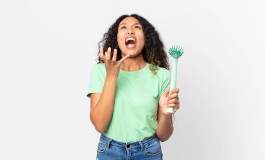 İspanyol güzel kadın umutsuz görünüyor, hayal kırıklığına uğramış ve stresli ve elinde bulaşık fırçası var.