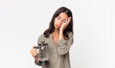 Genç İspanyol bir kadın bıkkın, hayal kırıklığına uğramış ve uykulu hissediyor. Yorucu bir günün ardından elinde bir el yapımı kahve makinesi tutuyor.