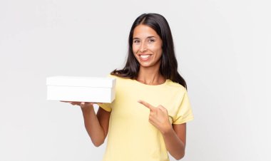 Genç İspanyol kadın neşeyle gülümsüyor, mutlu hissediyor ve bir tarafa işaret ediyor.