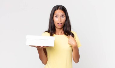 Şok olmuş ve ağzı açık, kendini işaret eden genç İspanyol bir kadın.