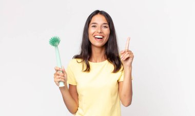 Genç İspanyol kadın bir fikri fark ettikten ve bulaşık fırçası tutduktan sonra mutlu ve heyecanlı bir dahi gibi hissediyor.