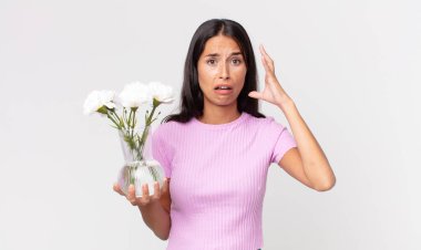 Süslü çiçekleri tutan genç İspanyol kadın ellerini havaya kaldırıp çığlık atıyor.