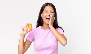 Genç İspanyol kadın kendini mutlu hissediyor, elleri ağızının yanında ve elinde pil tutarak bağırıyor.