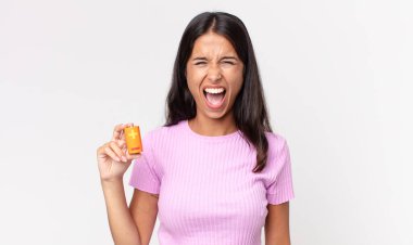 Genç İspanyol kadın saldırganca bağırıyor, kızgın görünüyor ve elinde piller var.