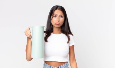 Genç İspanyol kadın üzgün ve sızlanıyor. Mutsuz bir bakışla, ağlıyor ve elinde kahve termosuyla.