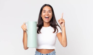 Genç İspanyol kadın bir fikri fark edip elinde kahve termosuyla mutlu ve heyecanlı bir dahi gibi hissediyor.