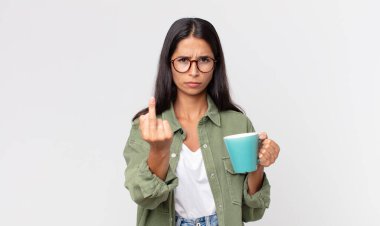 Genç İspanyol kadın kızgın, sinirli, isyankar ve agresif ve elinde kahve fincanı tutuyor.