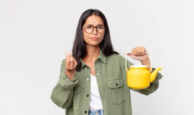 Genç İspanyol kadın kapiş ya da para hareketi yapıyor. Sana para ödemeni ve elinde çaydanlık tutmanı söylüyor.